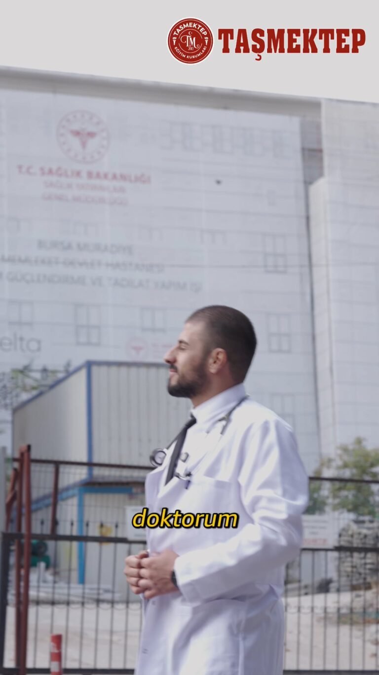 Taşmektep tanıtım filminden kare: okul binasının önünde beyaz önlüklü bir kişi